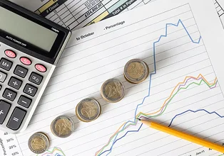 Calculator, coins, and financial graph illustrating cost savings and financial analysis for e-commerce business.